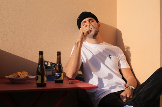 homme fumant avec un bonnet et un Tee shirt logo rose minimaliste blanc